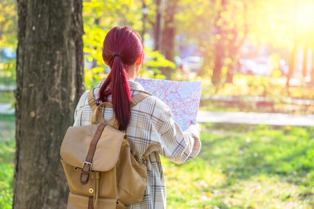 A girl tourist with a map in her hand, orienting herself in the areaの写真素材