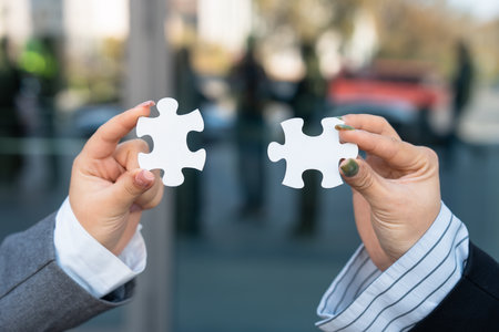 Business team members holding two puzzles, togetherness, team spirit, cooperation, business concept