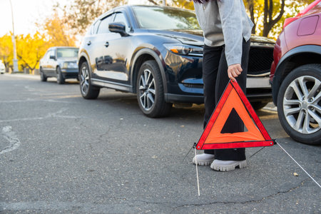 Car accident, the woman puts the warning sign on the ground.の写真素材