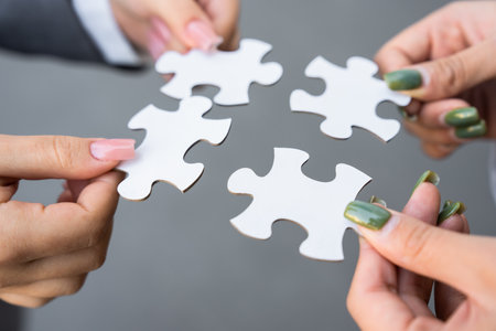 Business team members holding puzzles, togetherness, team spirit, cooperation, business conceptの写真素材