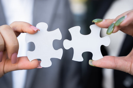 Business team members holding two puzzles, togetherness, team spirit, cooperation, business concept