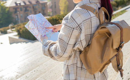 Tourist with map in hand orienting himself in the city