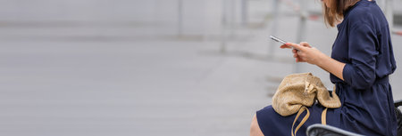 Woman using smartphone sitting on city bench