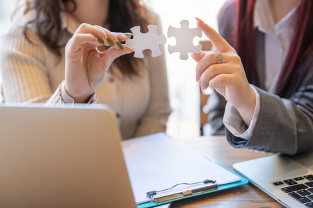 Piecing Together Success: Businesswomen Collaborating with Puzzle Pieces in Teamwork