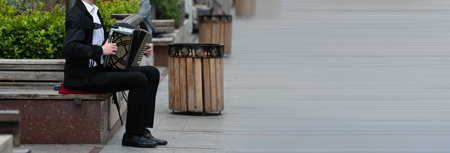 Accordionist, street musician plays, earns money, city streetの写真素材