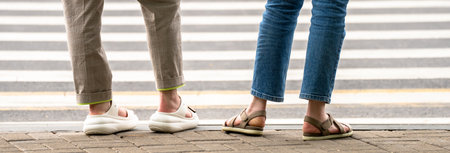 People waiting for the traffic light to cross the street, people's feetの写真素材