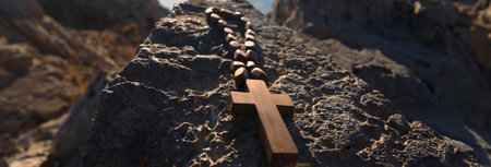 Wooden cross necklace on stone, mountain sceneの写真素材