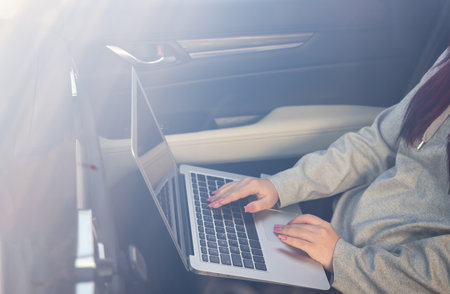 Working on a laptop in a car â Mobile business and productivityの写真素材