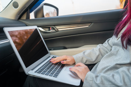 Working on a laptop in a car â Mobile business and productivityの写真素材