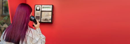 young woman talking on public telephoneの写真素材