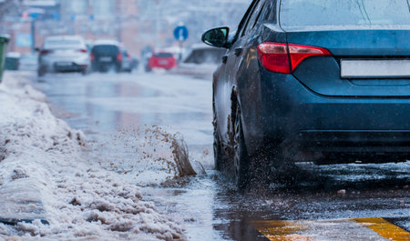 Puddles on the Road â Snowmelt and Drainage Problems Damaging Carsの写真素材