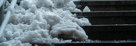 Clearing Snow from Stairs in Cold Winter Weatherの写真素材