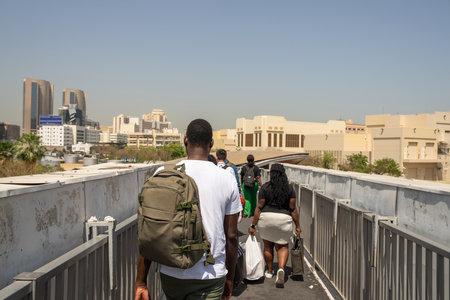 Black pedestrians cross the overhead pedestrian bridge