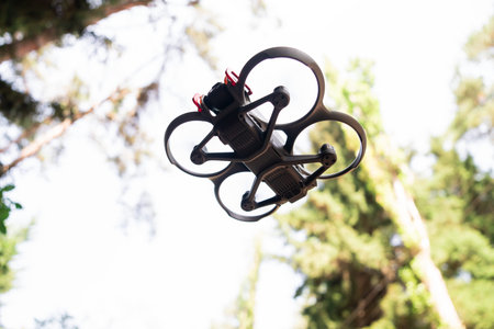 Drone flying above a dense forest, capturing aerial perspectives, exploring natural landscapes, and...