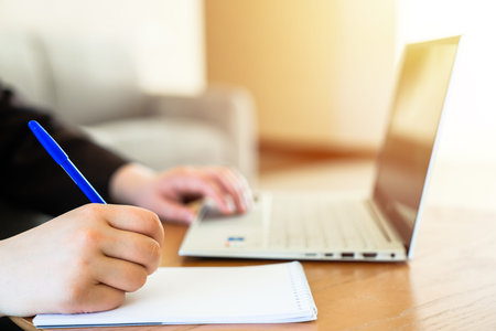 Business Worker Using Laptop and Taking Notes
