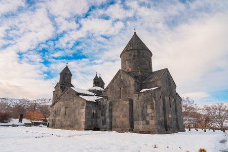 Exterior of an Armenian Apostolic church, showcasing traditional stone architecture, conical domes,...