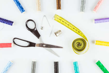 Composition with Scissors and Sewing supplies on white background. Colored thread bobbins.の写真素材