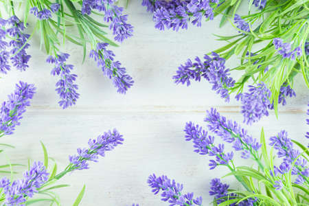 Lavender flowers arranged on white table background. Top view, flat lay mock up, copy space....
