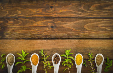 Fresh herbs and spices selection over old wood. Turmeric on dark vintage background with space for text. Top view.の写真素材