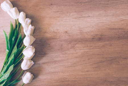 Beautiful tulips on white wooden background. Flat lay, top view, copy space. Table, petals. Close-up. Sunset lightの写真素材
