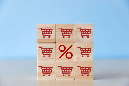 Wooden block with shopping cart graphic and discount percentage. Online shopping concept.