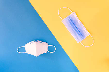 Medical flu mask on face, coronavirus prevention on yellow and blue background.の写真素材