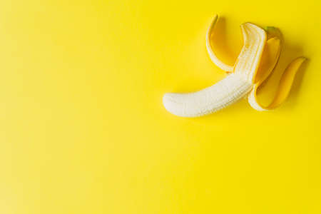 Peeled Banana on Yellow background Isolated. Copy space. Design. mockup. Top view. Healthy concept.の写真素材