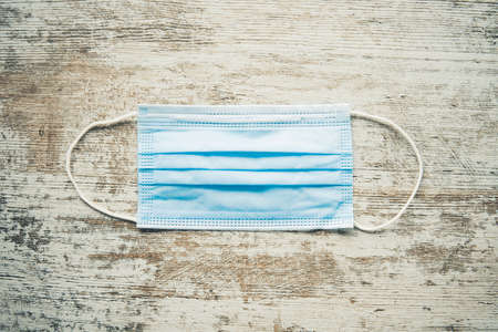 Medical face mask on a wooden background. Means of protection against the disease. Coronavirus. Disease control.の写真素材
