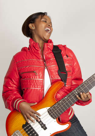 Young funky woman playing bass guitarの写真素材