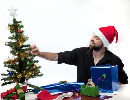 Handsome man wearing Santa Claus hat preparing gifts.の写真素材