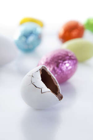 Easter Egg candy half eaten with colourful candy in background. の写真素材