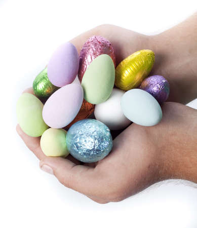Male Caucasian hands holding out colourful Easter egg candy.