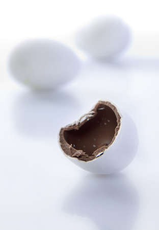 Easter Egg candy half eaten with colourful candy in background. の写真素材