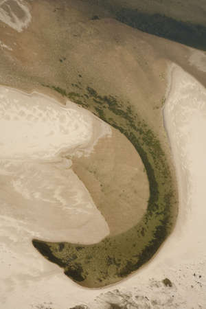 Aerial view of sany river bed with river creating abstract forms through the sand.