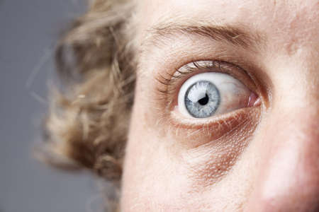 Closeup of a blue eye, of a Caucasian man, showing intricate details of the iris.の写真素材