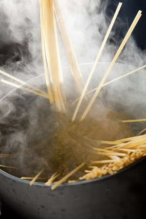 Spaghetti being cooked in hot water with steam making a dramatic image.の写真素材