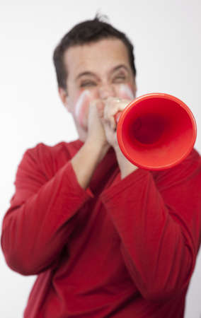 Man in red blowing vuvuzelaの写真素材