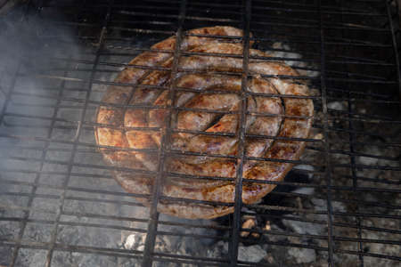 South African lamb sausage, known as boerewors, being grilled over hot coals, as part of a traditional South African cooking tradition called "braai".の写真素材