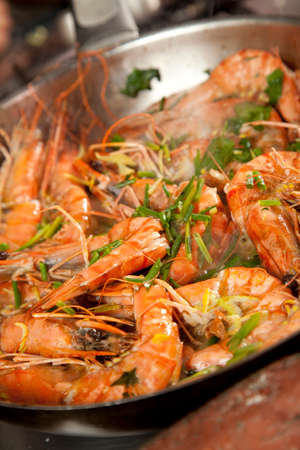 Fresh prawn, or shrimp being pan fried with cilantro and herbs in a pan.の写真素材