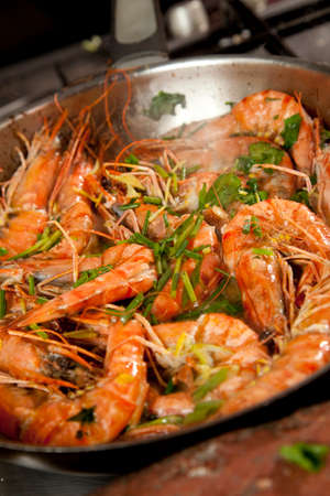 Fresh prawn, or shrimp being pan fried with cilantro and herbs in a pan.の写真素材