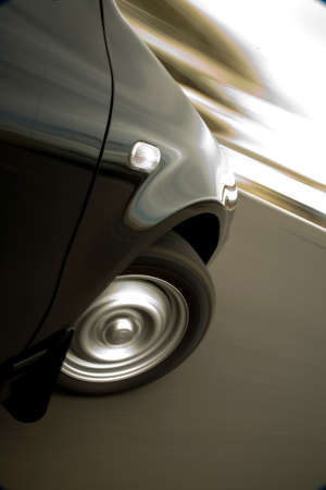 Black car turning sharply to its right, showing speed in tracking blur.の写真素材