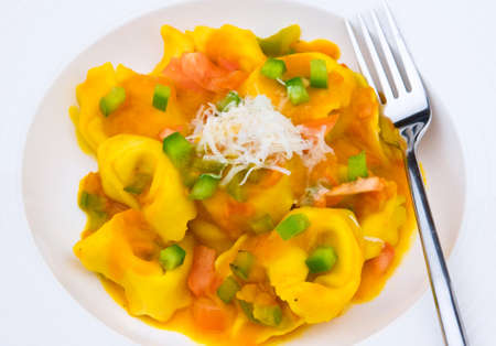 Tortellini with pumpkin  sauce, pepper and parmesan の写真素材