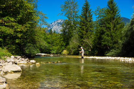 Fisherman fly fishing at river Sava Bohinjka  