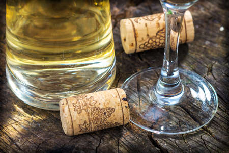 White wine and corks on wooden table.の写真素材