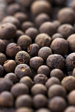 Allspice pepper on the rustic wooden background