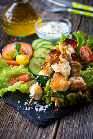 Chicken and vegetable skewers with  garlic dip and saladの写真素材