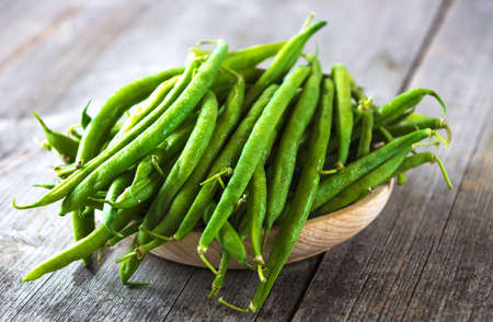 Green beans on wooden background