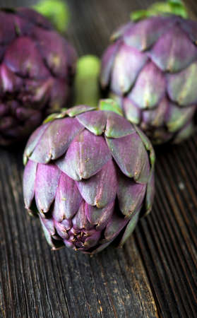 Organic Artichokes on  rustic wooden boardの写真素材