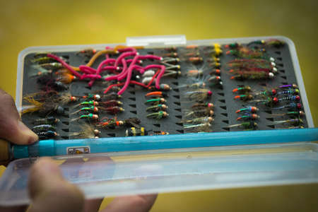 Fly fisherman  chooses a fly for flyfishing trout
