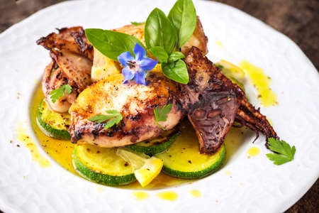 Grilled squid with lemon and zucchini on wooden backgroundの写真素材
